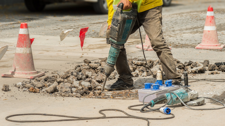 A person jackhammering concrete