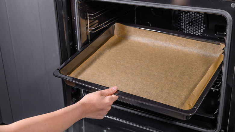 Woman taking baking pan out of oven