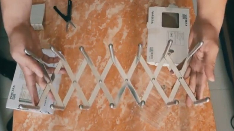 Person holding stainless steel pot lid organizer