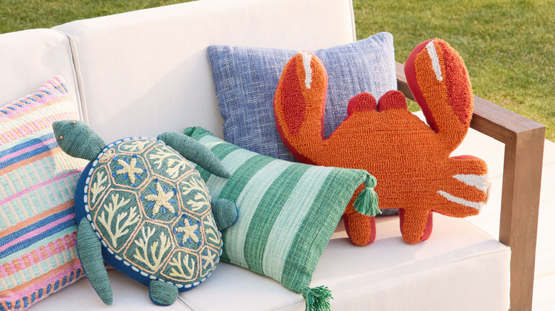 assortment of outdoor throw pillows in various colors, patterns, and shapes