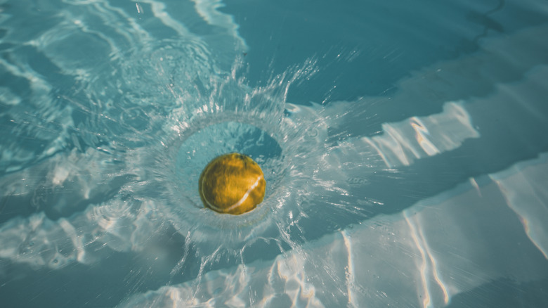 tennis ball splashing into pool