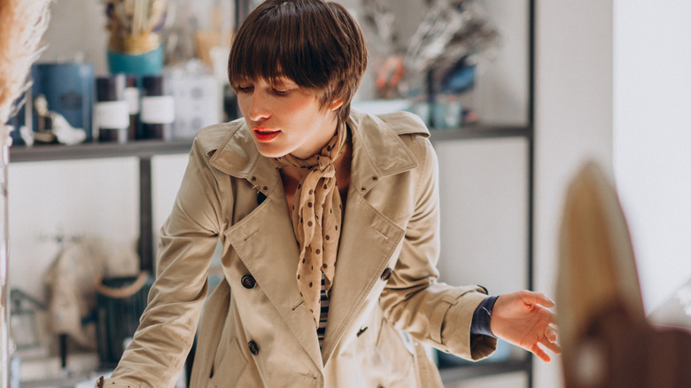 A woman reaches for an item in a decor store
