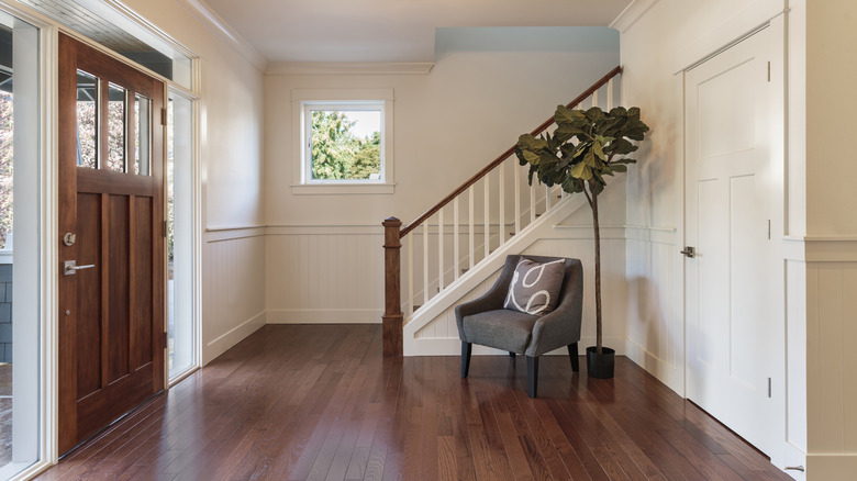 entryway of a home with a wood front door, hardwood floors, and white walls