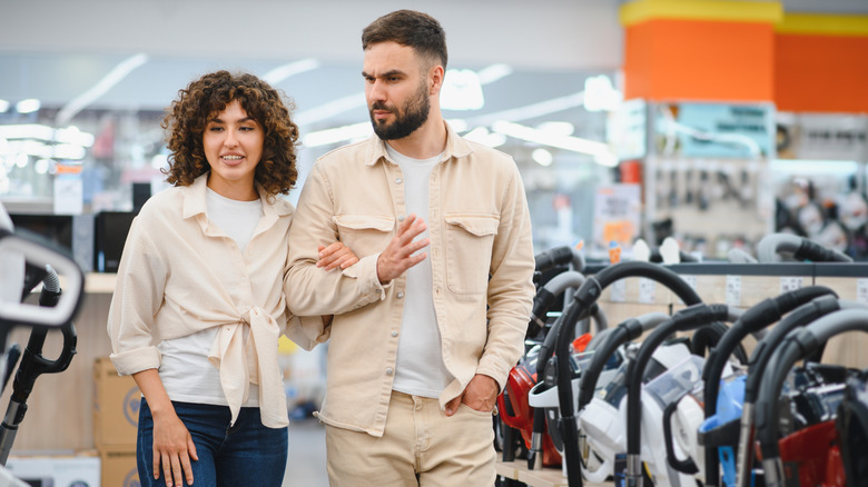 Two people talking in a vacuum aisle