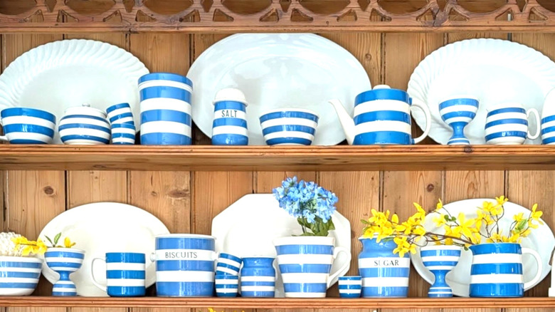 Cornishware blue and white striped pottery on a wood shelf