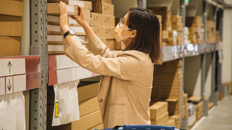 woman taking box from shelf in ikea store