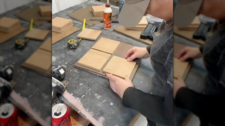 Woman refurbishing IKEA shelving unit with common tools and materials on worktable