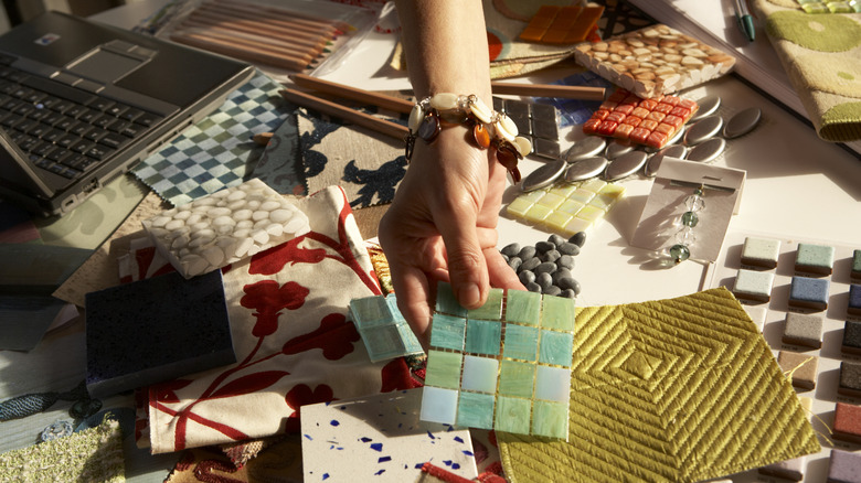 Woman looking through interior design fabric and tile samples