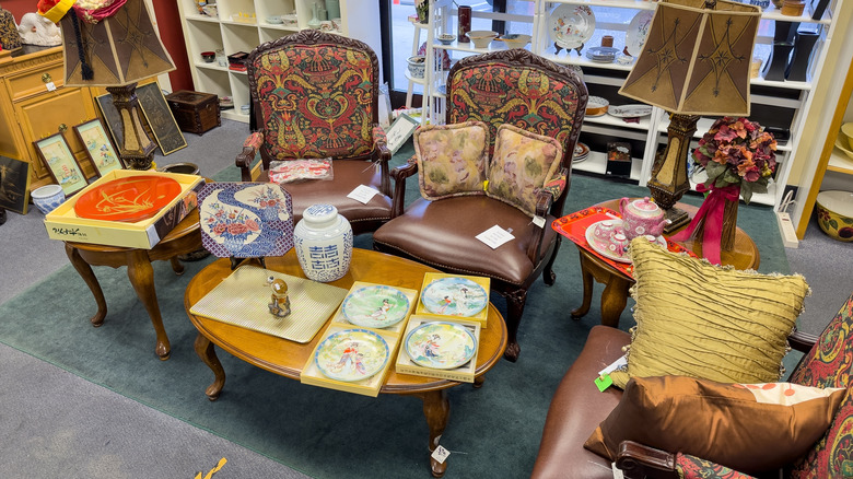 Vintage chairs arranged around a wood table at a thrift store