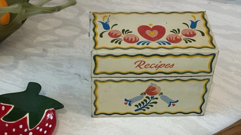 A vintage recipe box on a counter.