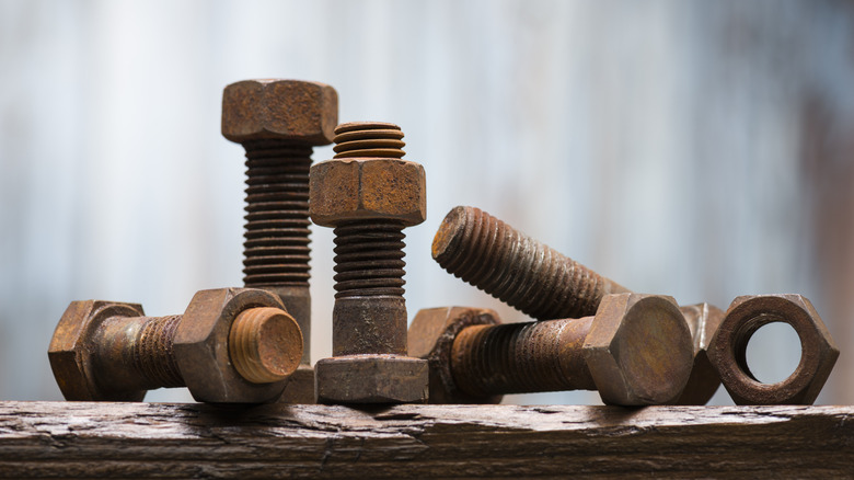 Rusty nuts and bolts on wooden table