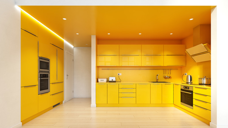 A modern kitchen in painted almost entirely in bright yellow.