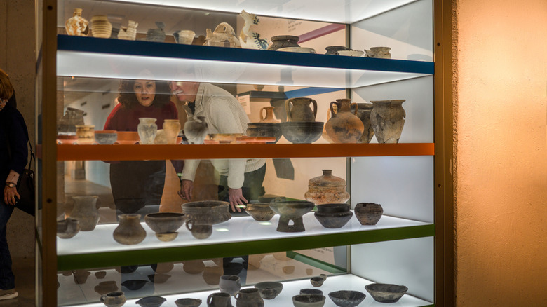 People looking at pottery at a museum