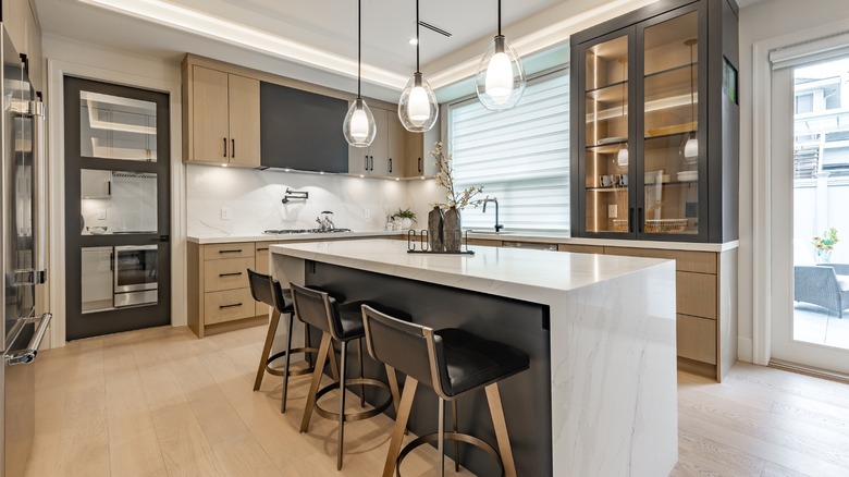 Bright modern kitchen with layered pendant, under-cabinet, and strip lighting