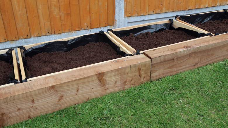 Raised garden beds with landscape fabric and soil