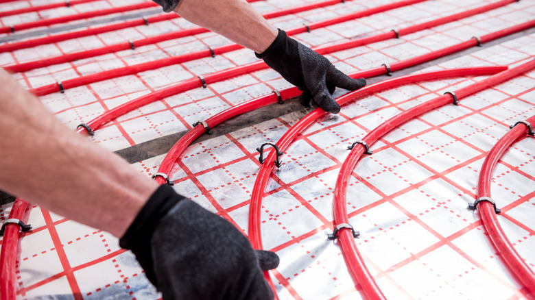 Person installing a heated flooring system