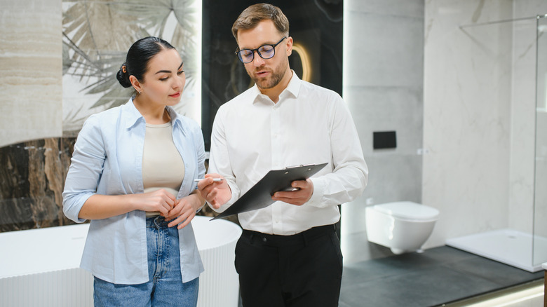A man talking with customer in bathroom remodel showroom