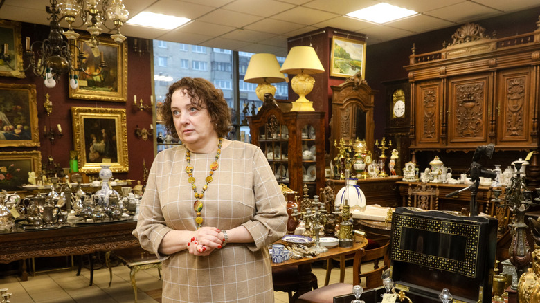 A woman stands in an antique store
