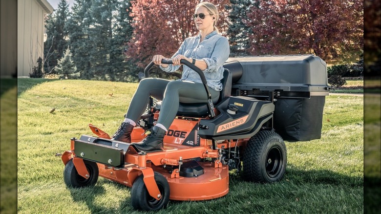 A woman rides an orange Ariens Edge LT 42-inch Zero-turn riding lawn mower
