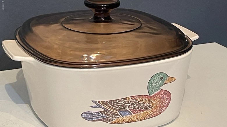 A Corningware casserole with a Mallard duck pattern and amber lid