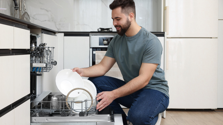 Man unloading dishes from dishwasher