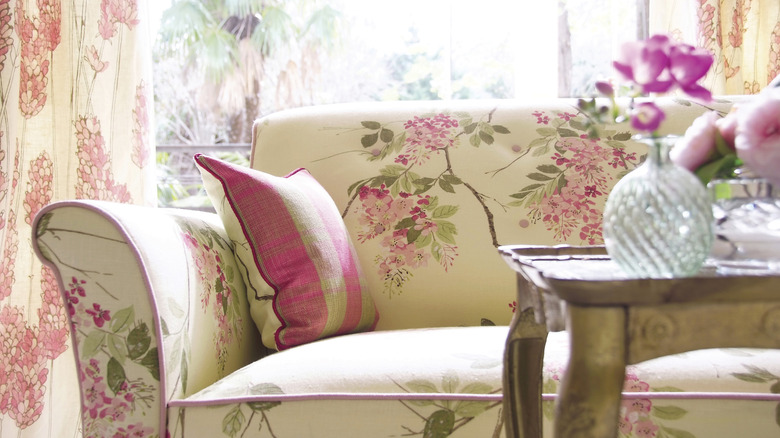 White, pink, and green floral sofa near a coffee table