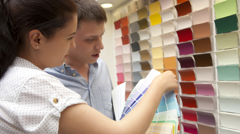 A couple looks at paint color chips together
