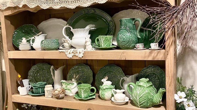 A display cabinet showing cabbage plates, teacups, and teapots