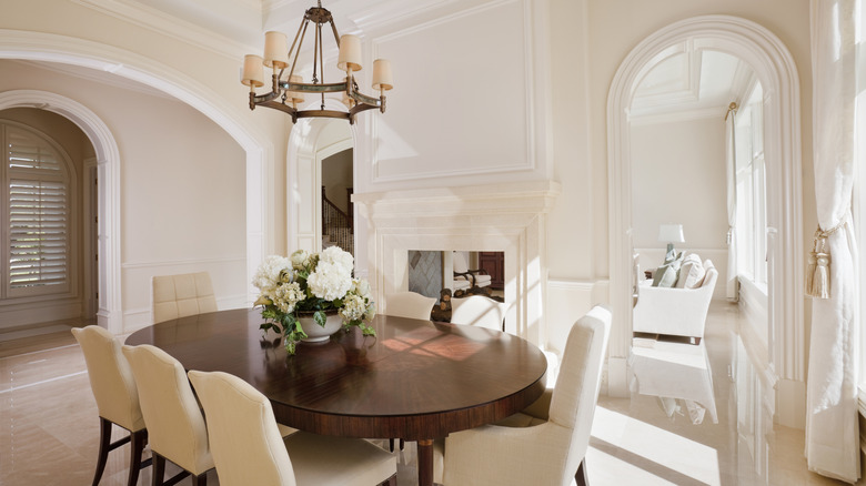 formal walled in dining room with arched doorways and cream colored moldings