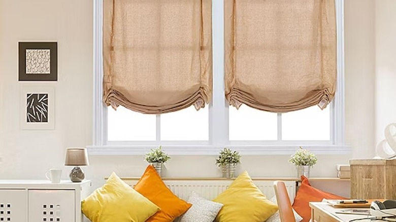 tan tulip Roman shades in an outdated living space
