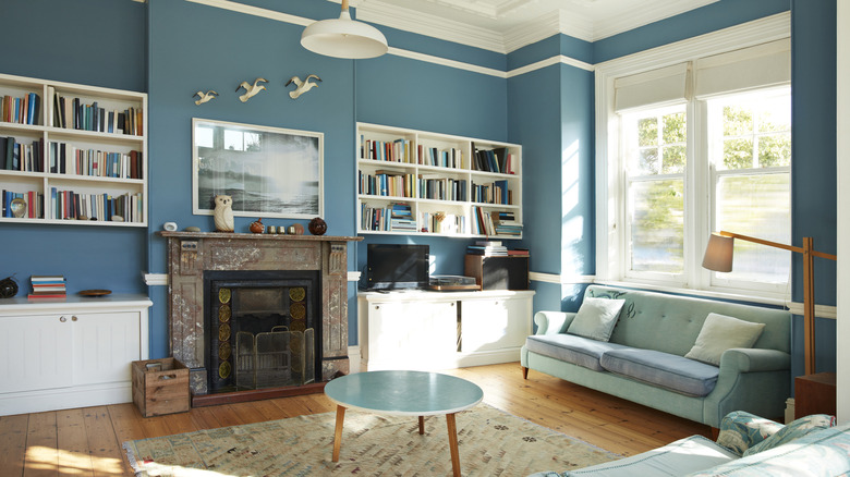 dark blue ornate fireplace in a room with floral wallpaper