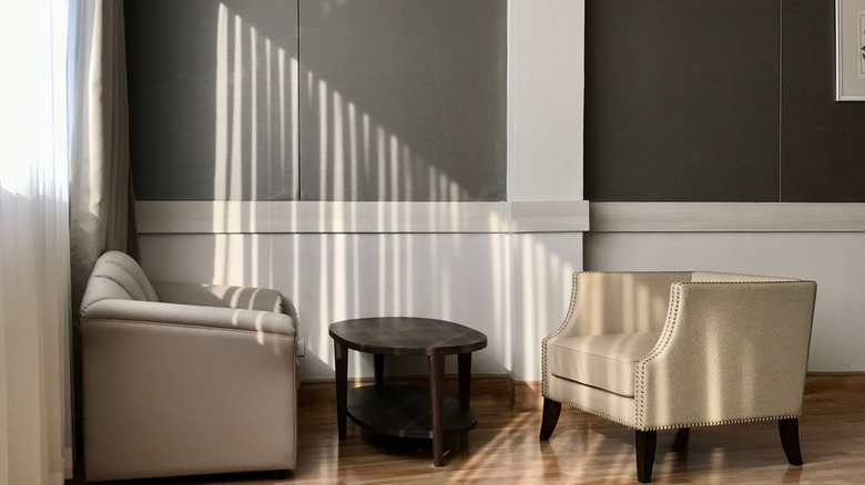 Living room with half-gray and half-white walls with decorative moulding