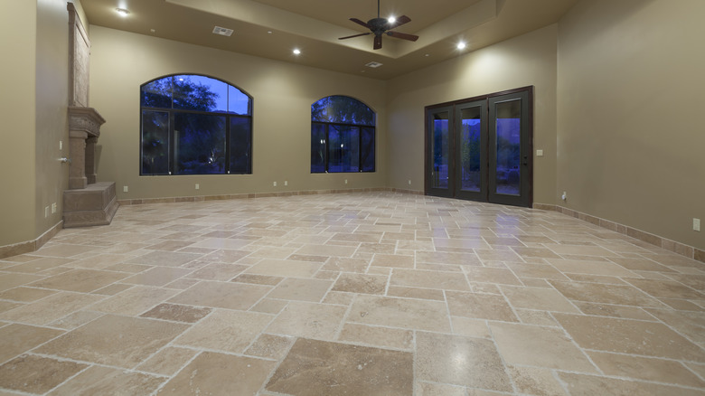 Empty entryway of a home with travertine flooring