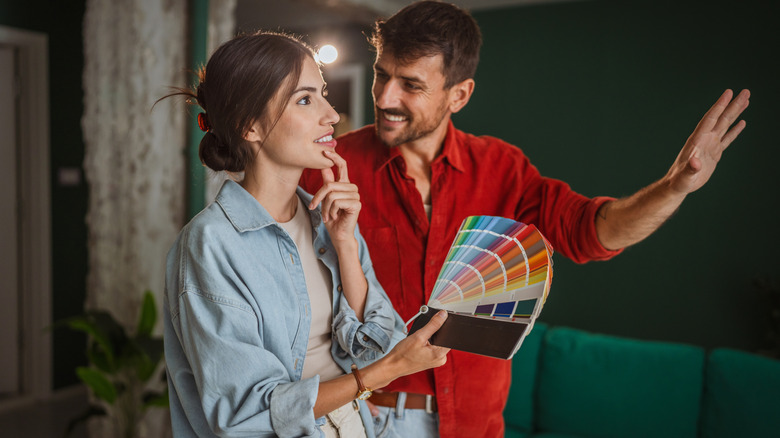 A couple looks at paint swatches for their house