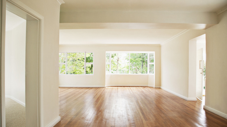An empty home lit by sunlight with neutral-colored paint on the walls