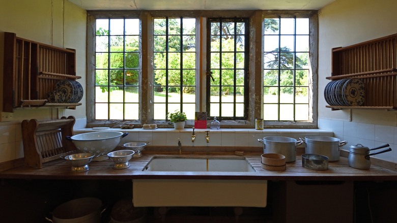 A kitchen in a Victorian home with wood countertops by a farmhouse sink