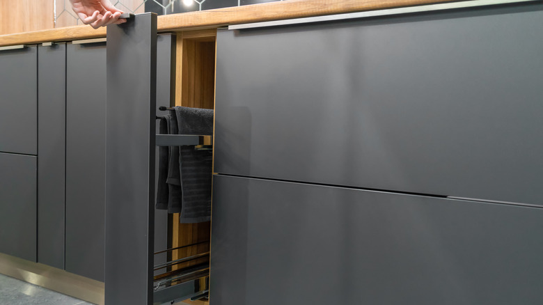 Slide-out towel rack built into modern kitchen cabinet
