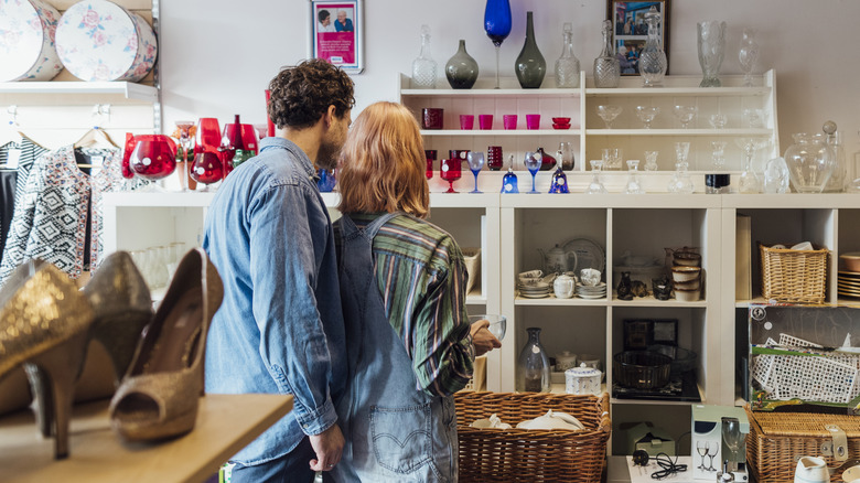 A couple checking out items in a thrift store.
