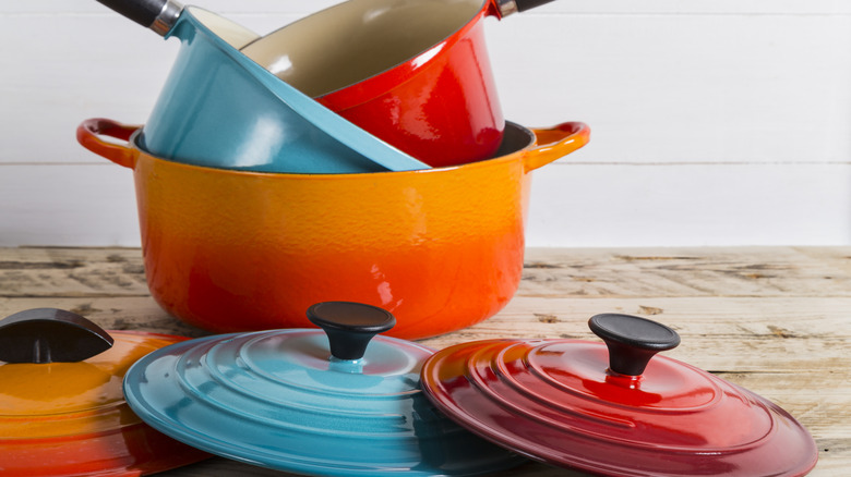 Colorful Le Creuset pots and pans with lids