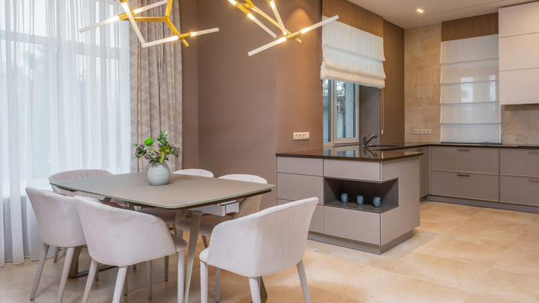The walls of an open kitchen and dining room are painted a muted clay color