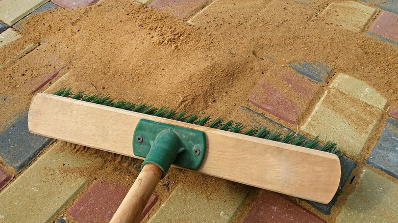 Spreading sand into paver joints