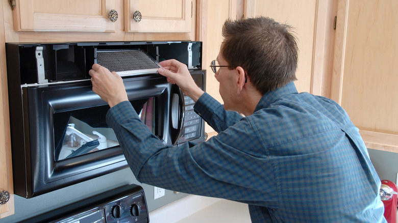 Man removing microwave filter