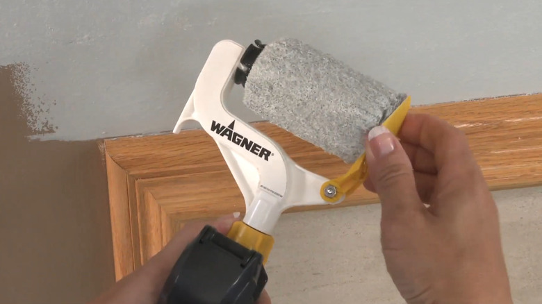 A painter uses the Wagner Smart Edge Manual Trigger Roller