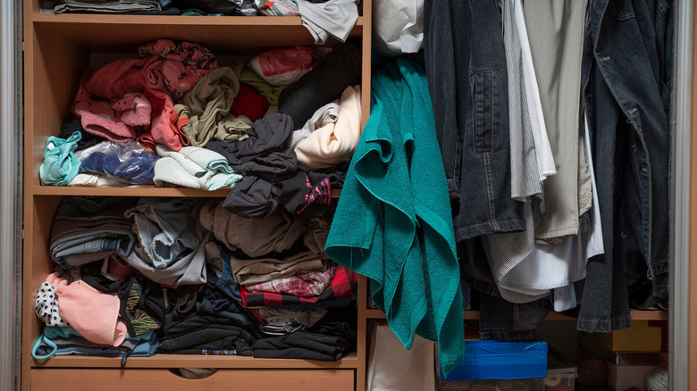 Clothes crammed in a wood closet