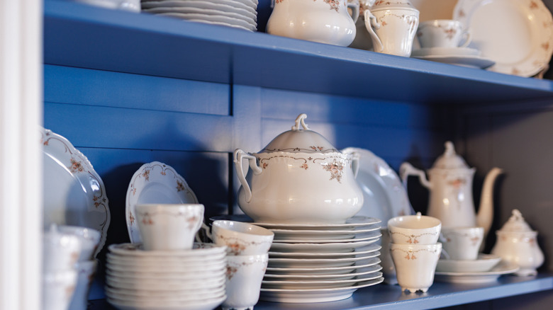 Set of fine china sitting in a blue cabinet