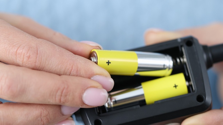 Person pulling a rechargeable battery from a device