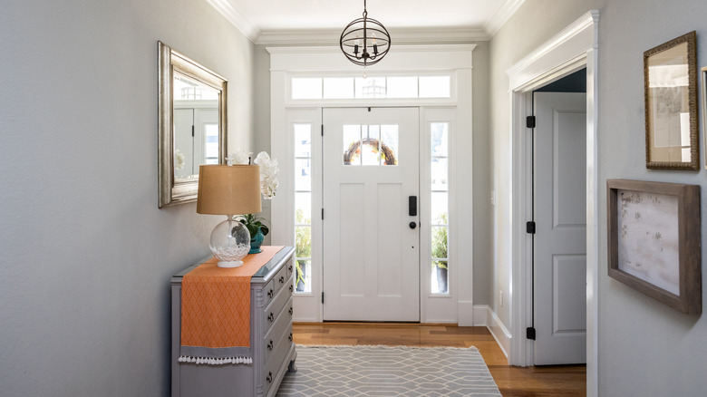 A transom window lights a large white foyer