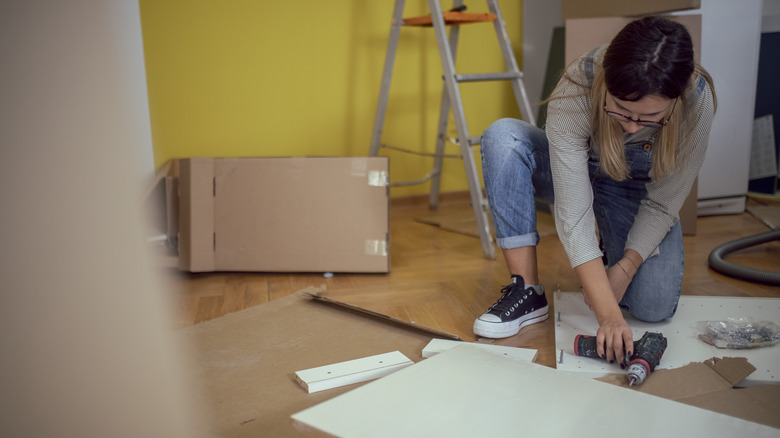 woman building white IKEA furniture