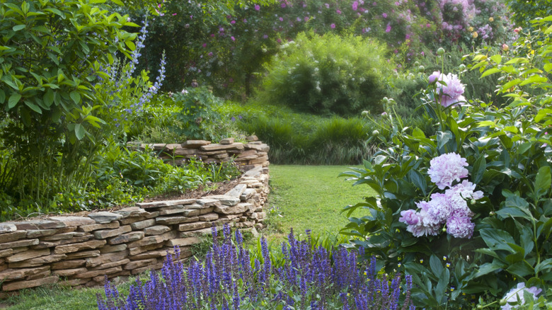 A flower garden with stacked flagstone garden bed edging