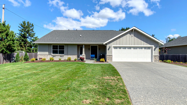 A ranch house with a poured concrete driveway